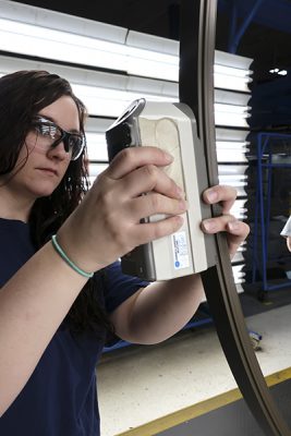 Woman holding gauge up to aluminum finished material